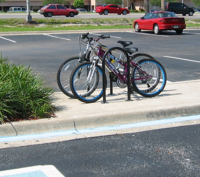 "Inverted U" bike racks provide two points-of-support for each bike, support locking the bike securely, AND hold 2 bikes per "U", one on each side. Multi "U" strips are available where only 4 attachment points to the pavement are used, just like the current Hardee's bike rack. 